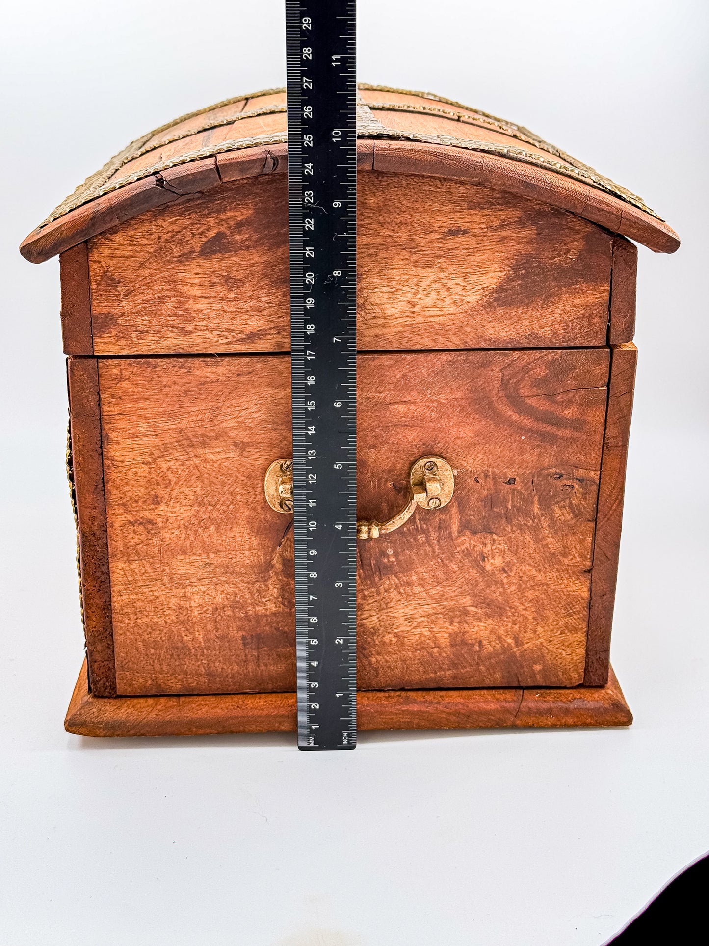 Close-up of chipped corner on vintage Indian brass-inlay wooden chest showing condition