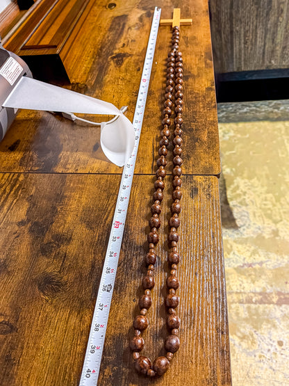 Close-up of deep burgundy wood beads showing mottled organic grain and spacer beads