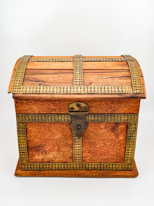 Close-up of hand-stamped brass inlay floral banding on corner of vintage Indian dome-top wooden chest