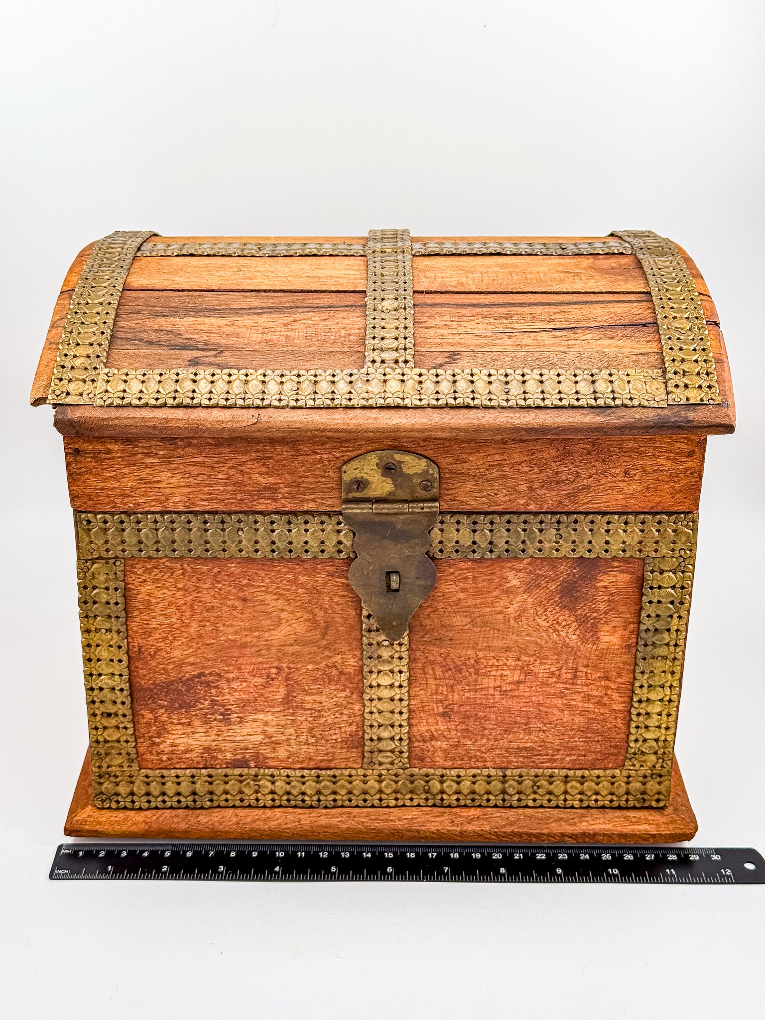 Top view of vintage Indian brass-inlay dome-top wooden chest showing brass cross banding on lid
