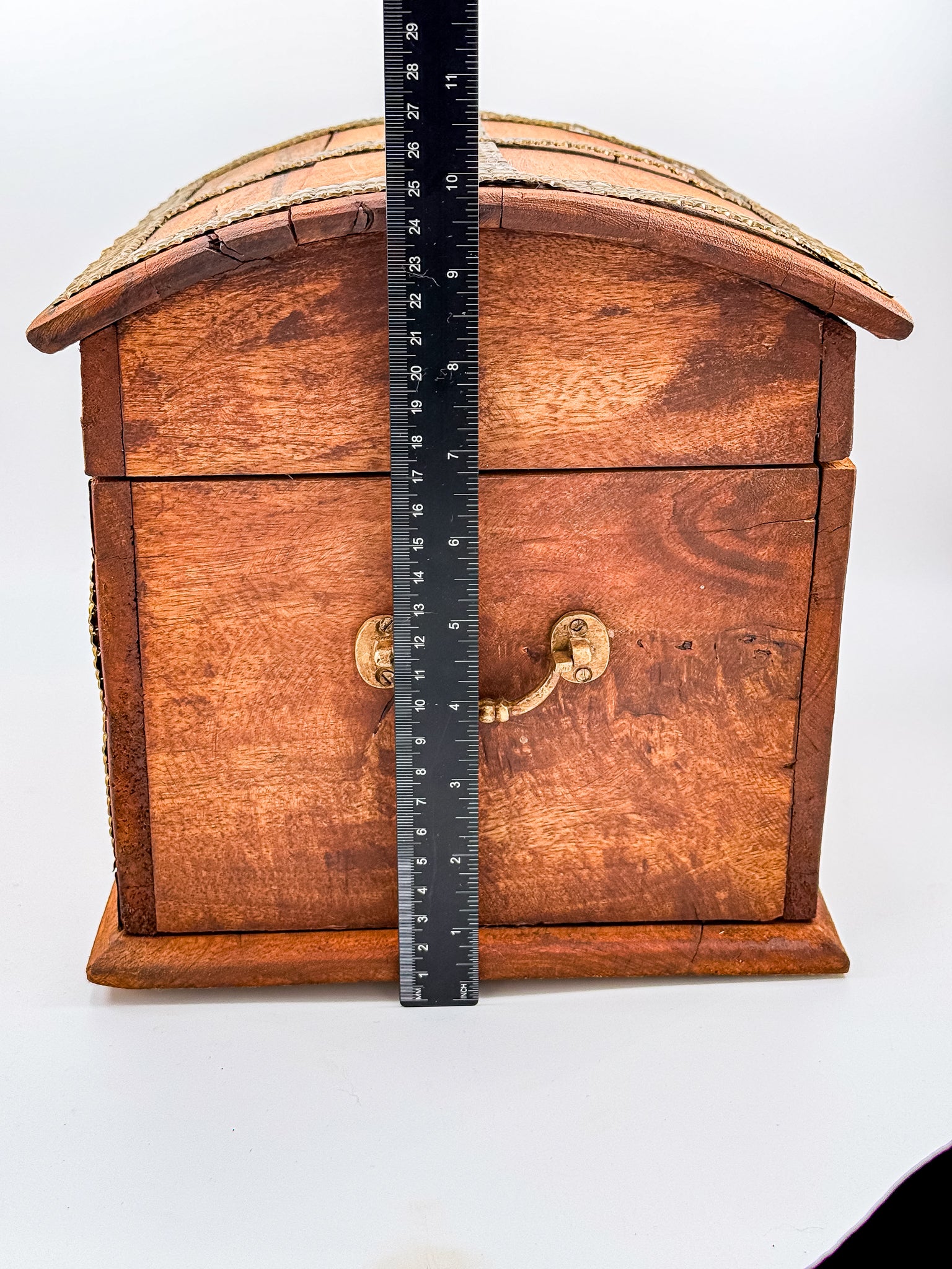 Close-up of chipped corner on vintage Indian brass-inlay wooden chest showing condition