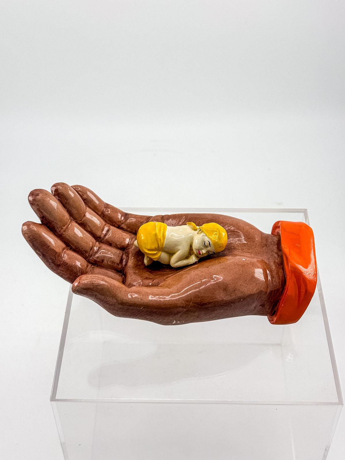 Ceramic Hand Sculpture with Sleeping Figure and Orange Cuff - Possibly Religious