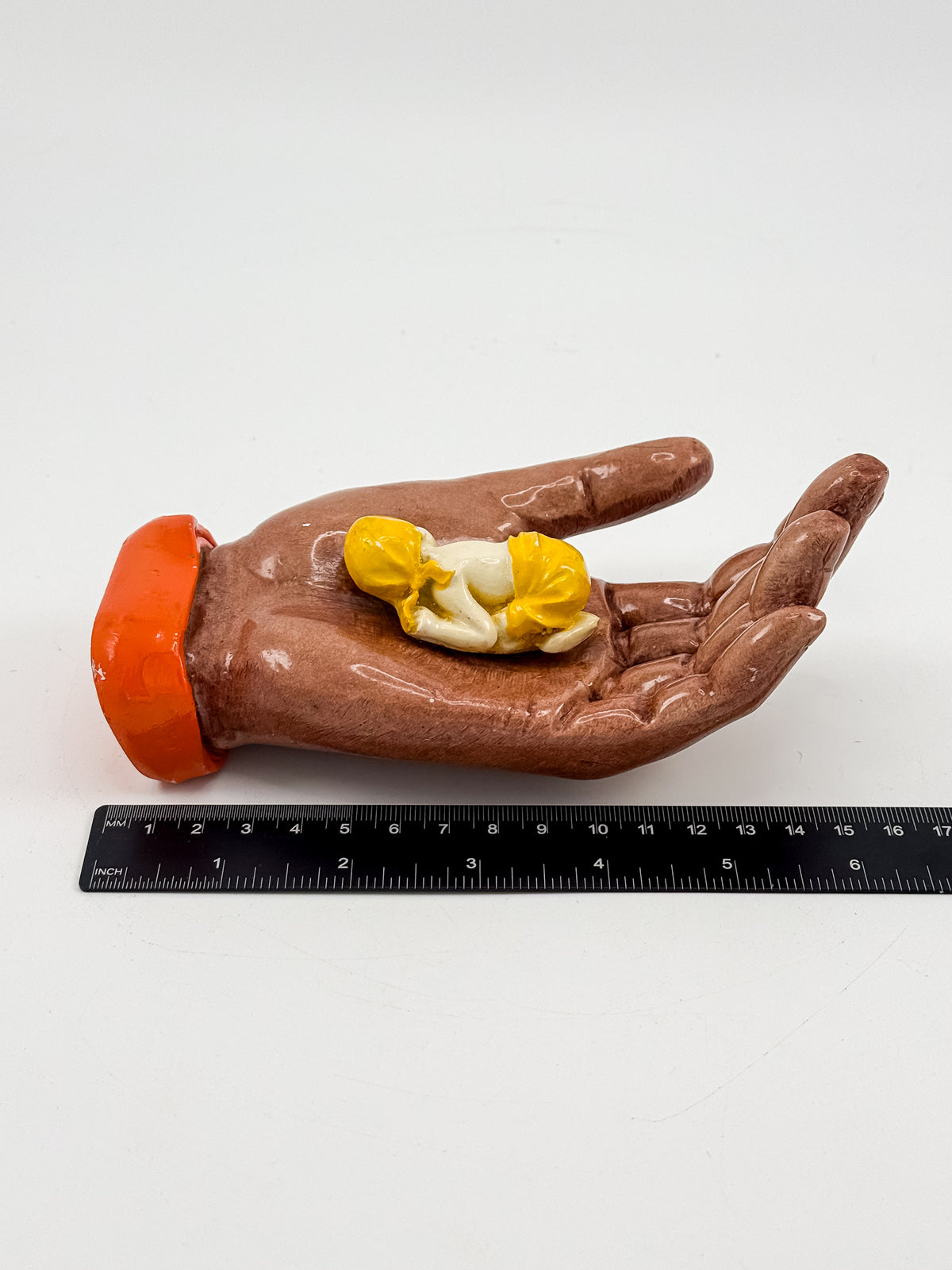 Ceramic Hand Sculpture with Sleeping Figure and Orange Cuff - Possibly Religious